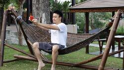 young man taking a selfie in the garden by smart phone Stock Footage