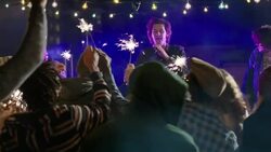 Wide dolly shot of lead guitar through party crowd with sparklers Stock Footage
