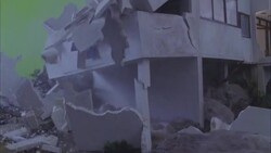 A building collapses in a flood simulation as water surges around it. Stock Footage