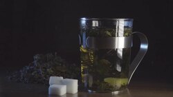 Sugar falls in Peppermint tea slowmotion Stock Footage