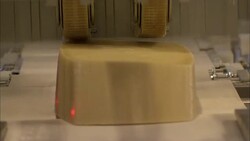 Blocks of cheese pass through a slicing machine at a food-processing plant in Bern, Switzerland. Stock Footage