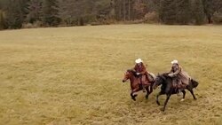 AERIAL Two people riding galloping horses across countryside Stock Footage