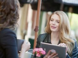 Women have coffee and look at tablet Stock Footage