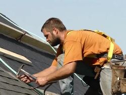MS Shot of worker sweating while on his knee hammering / Chelsea, Michigan, United States Stock Footage