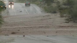 A flash flood overcomes a rural road, stopping traffic from crossing over the roadway in Arizona. Stock Footage