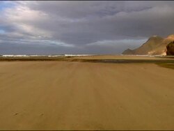 Sand blowing to camera, beach pan, Andalucia, Spain Stock Footage