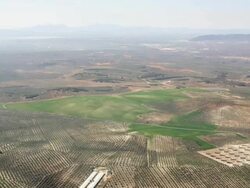 WS aerial view of olive plantations with the lagoon of Fuente de Piedra and the mountains of the Sierra de las Nieves in the background Stock Footage