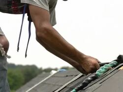 MS TD Shot of worker hammering at top of roof / Chelsea, Michigan, United States Stock Footage