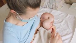 Sick mother in mask breastfeeding her baby Stock Footage