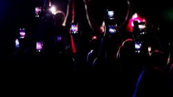 Crowd waving arms holding cell phones at concert Stock Footage