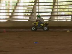 Child drives ATV through the obstacle course. Stock Footage
