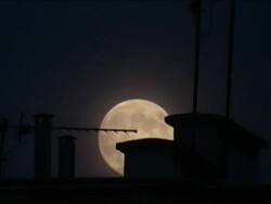 full moon rising over roofs, 4:3 Pal Stock Footage