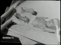 1946: BLACK MARKET BABY: Newspaper clipping on Black Market Babies. DRAMATIZATION: Impatient couple looking at photographs of baby. Male hand signing check for $1500.00. Doctor checking baby SOT saying baby heart condition, will be invalid. CU Baby. Instructional Video