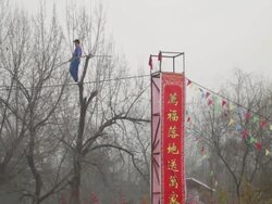 MS PAN ZO Acrobats performing high wire act during spring festival temple fair at small wild goose pagoda park AUDIO / xi'an, shaanxi, china Stock Footage