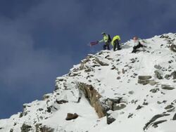 WS PAN Mountain climber throwing guide rope down while descending on snow covered mountain in Austrian Alps by abseiling / Stubai Glacier, Tirol, Austria  Stock Footage