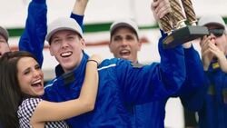 Race-car driver holds up trophy, blue racing team celebrates stock car victory Stock Footage