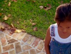 high angle MS PAN PORTRAIT Asian girl looking up at camera + smiling outdoors Stock Footage