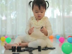 Little girl playing with black domino Stock Footage