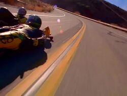 CANTED close up tracking shot two street lugers speeding on mountain road signal + stop / sun flare in shot Stock Footage