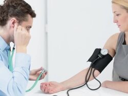 HD: Doctor Measuring Blood Pressure to mid adult woman. Stock Footage