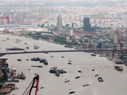WS HA View of multiple barges sailing along Hungpu River and bridge / Shanghai,  China Stock Footage