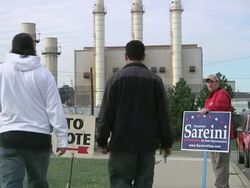 November 2, 2010 PAN Two young men walk towards a campaign worker holding a picket sign for the midterm election in the 14th Congressional District / Young men walking to voting precinct/Dearborn, Michigan, United States Stock Footage