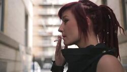 Close up cool young woman with red hair smoking cigarette Stock Footage