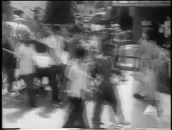 B/W 1959 PAN group of men carrying banners walk in street + cheer / celebrating revolution in Havana Stock Footage