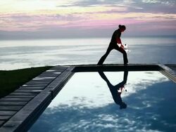 WS Male poi dancer performing in front of pool with reflection of his silhouette in pool at sunrise / Montezuma, Costa Rica Stock Footage