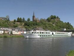 WS PAN Boat moving on river Saar with old town and castle ruin / Saarburg, Saar-Valley, Rhineland-Palatinate, Germany Stock Footage