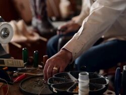 MS boot maker tacking vamp to sole of cowboy boot sitting near table with selection of tacks Stock Footage
