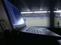 An open laptop operates on a moving subway train. Stock Footage