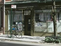 MS TD from top of Greenwich Village brick apartment building to Laundromat Drycleaner storefront on quiet side street - Signage removed / Manhattan, New York, USA Stock Footage
