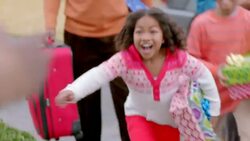 Grand-daughter runs into grandpa's arms and kisses his cheek as family arrives for Christmas Stock Footage