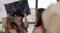 Two young women try on cowboy hats in Texas Western store Stock Footage