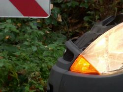 CU Car standing on autumnal street side in forest with red indicator / Saarburg, Rhineland-Palatinate, Germany Stock Footage