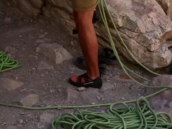 Tilt shot of a rock-climber arraigning his footwear. Stock Footage