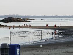 playland beach in Rye New York with people, fence, and trash cans at sunset Stock Footage