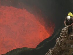 Man stands on cliff overlooking active volcano lava lake, Marum Volcano, Ambrym Island, Vanuatu Stock Footage