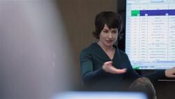 Insightful businesswoman leads meeting in corporate boardroom, gestures animatedly at data on big-screen Stock Footage