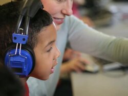 CU TD Student wearing headphones sitting in computer lab with teacher / Richmond, Virginia, United States  Stock Footage