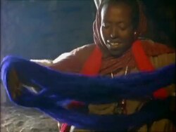 MS Woman preparing blue wool for rolling, Young lamb in background, Ethiopia, Africa Stock Footage
