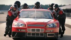 Pit-crew team pushes race-car Stock Footage