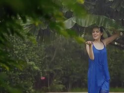 Young woman under a palm leaf in rain season, Delhi, India Stock Footage