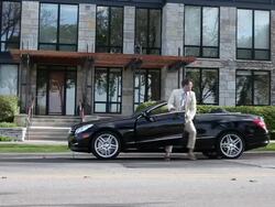MS PAN Young well dressed man driving  modern convertible car up to modern apartment building and running up to front door / Minneapolis, Minnesota, United States Stock Footage