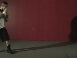 Camera moves from shadow to reveal man boxing Stock Footage