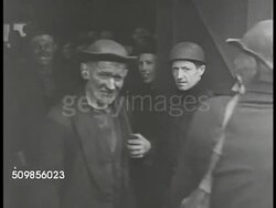 1946: FRANCE COAL MINING: WS French coal miners coming out of mine, dirt on face. MS Worker pushing cart on tracks into building. MS Carts filled w/ coal on tracks entering building. Labor Instructional Video