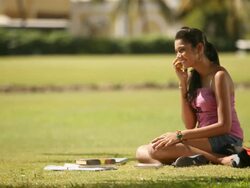 College girl sitting in a park and talking on mobile phone Stock Footage
