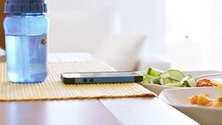 Child having his lunch and scrolling on mobile Stock Footage