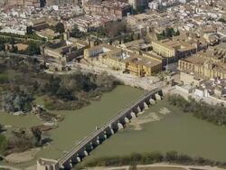 aerial view of historic city center of Cordoba with Cathedral-Mosque in center and Roman bridge spanning Guadalquivir river Stock Footage